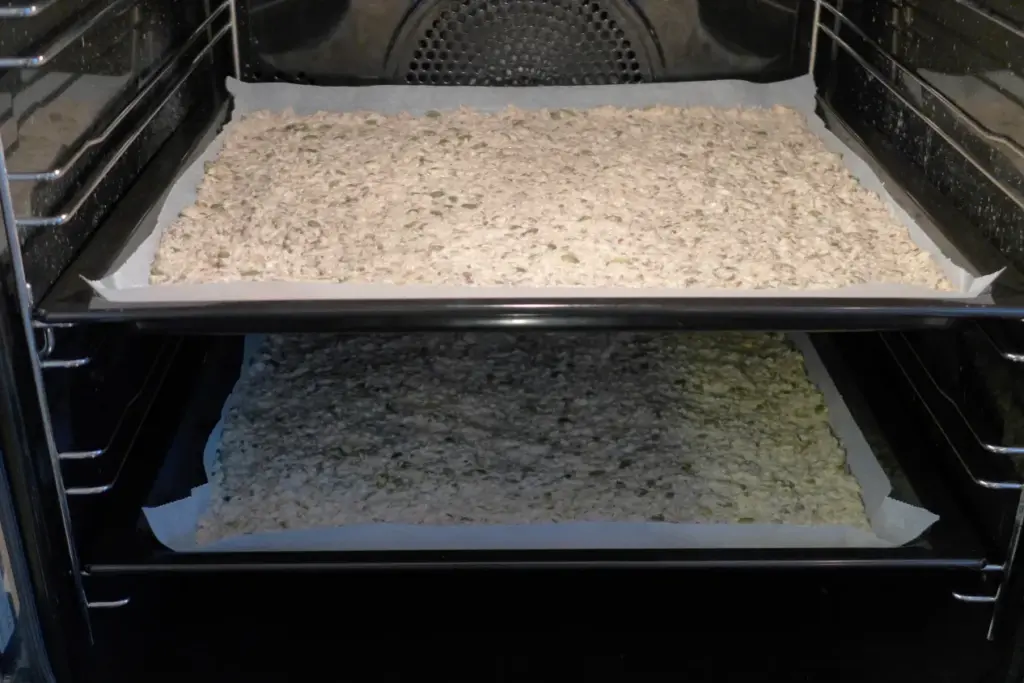 Hjemmelaget knekkebrød med frø på bakepapir før steking
