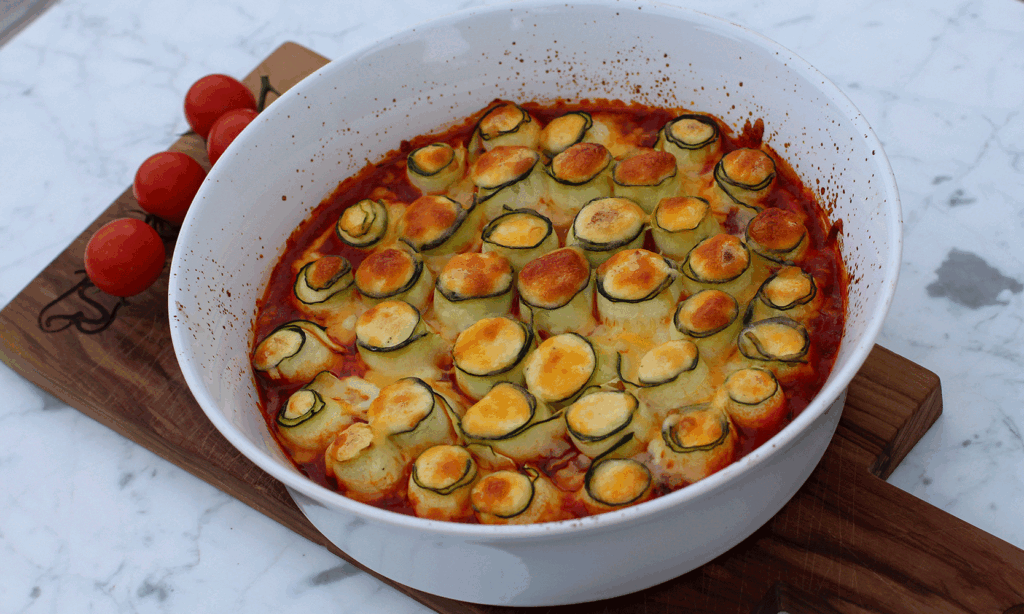 Squashruller med ricotta i tomatsaus i hvit form på treplate