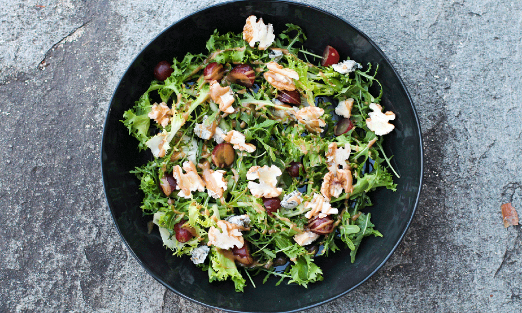 Valnøttsalat med rester på sort fat