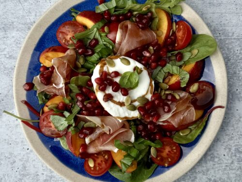 burrata- og nektarinsalat på blå tallerken