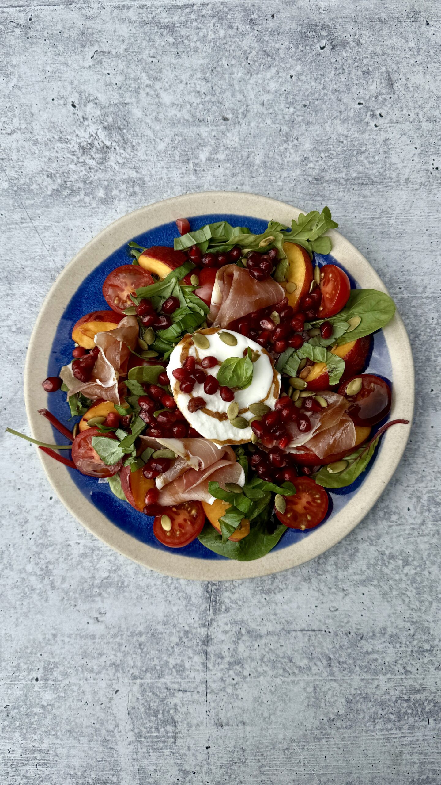 burrata- og nektarinsalat på blå tallerken