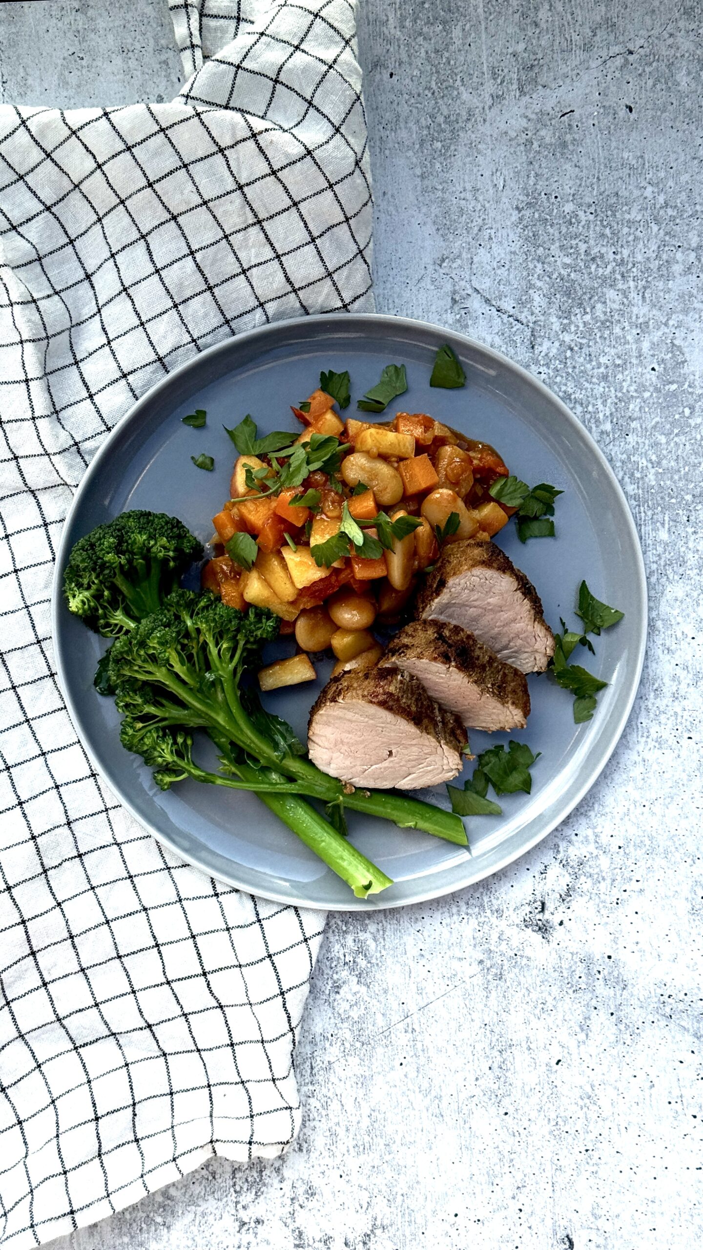 blå tallerken med svinefilet med tomatbønner