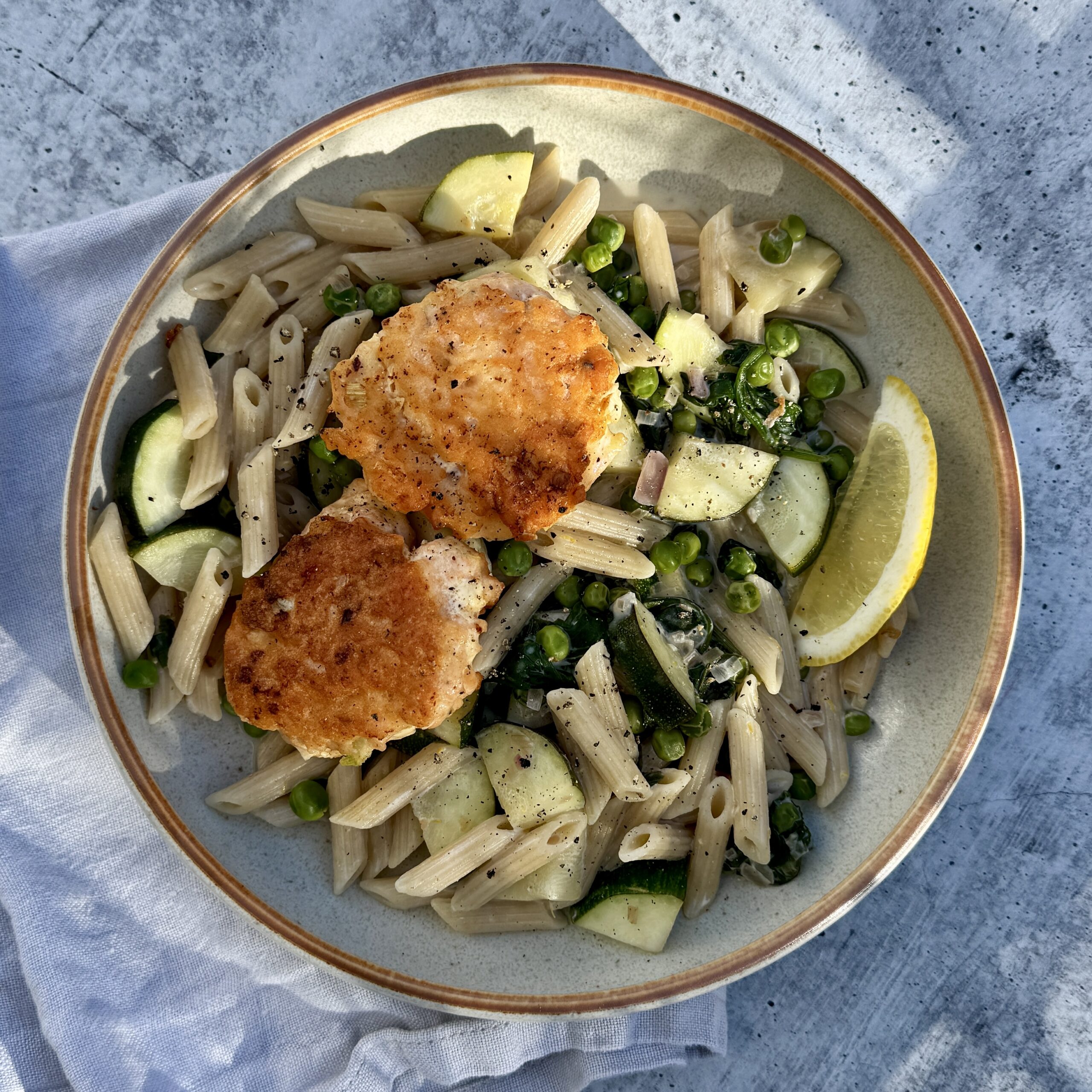 laksefiskekaker med kremet pasta i beige skål